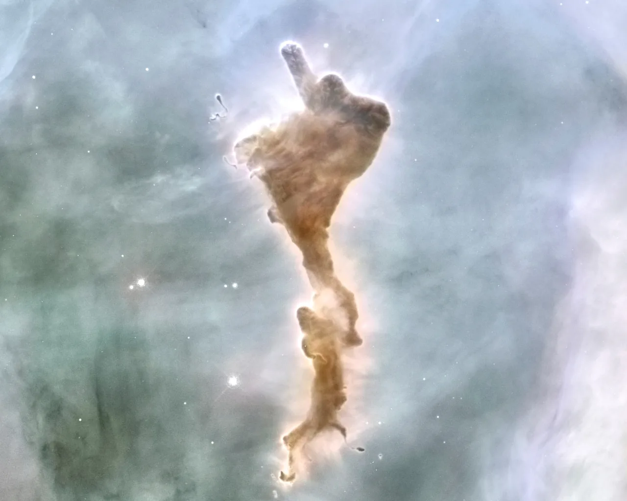 A dark finger-shaped cloud of dust against glowing pale gas.