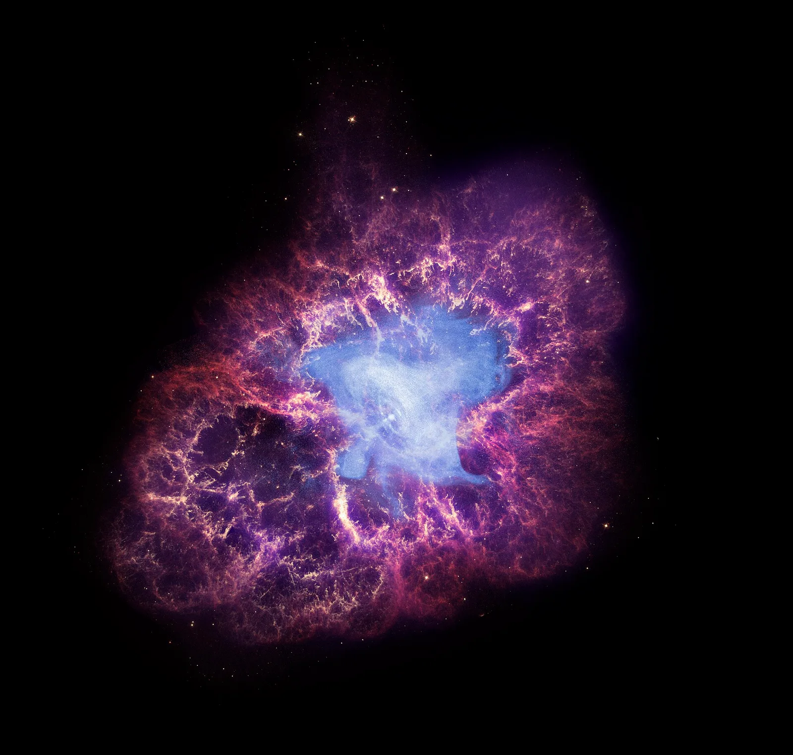 The Crab Nebula: a tangled shell of red and orange filaments around a pale blue glow.