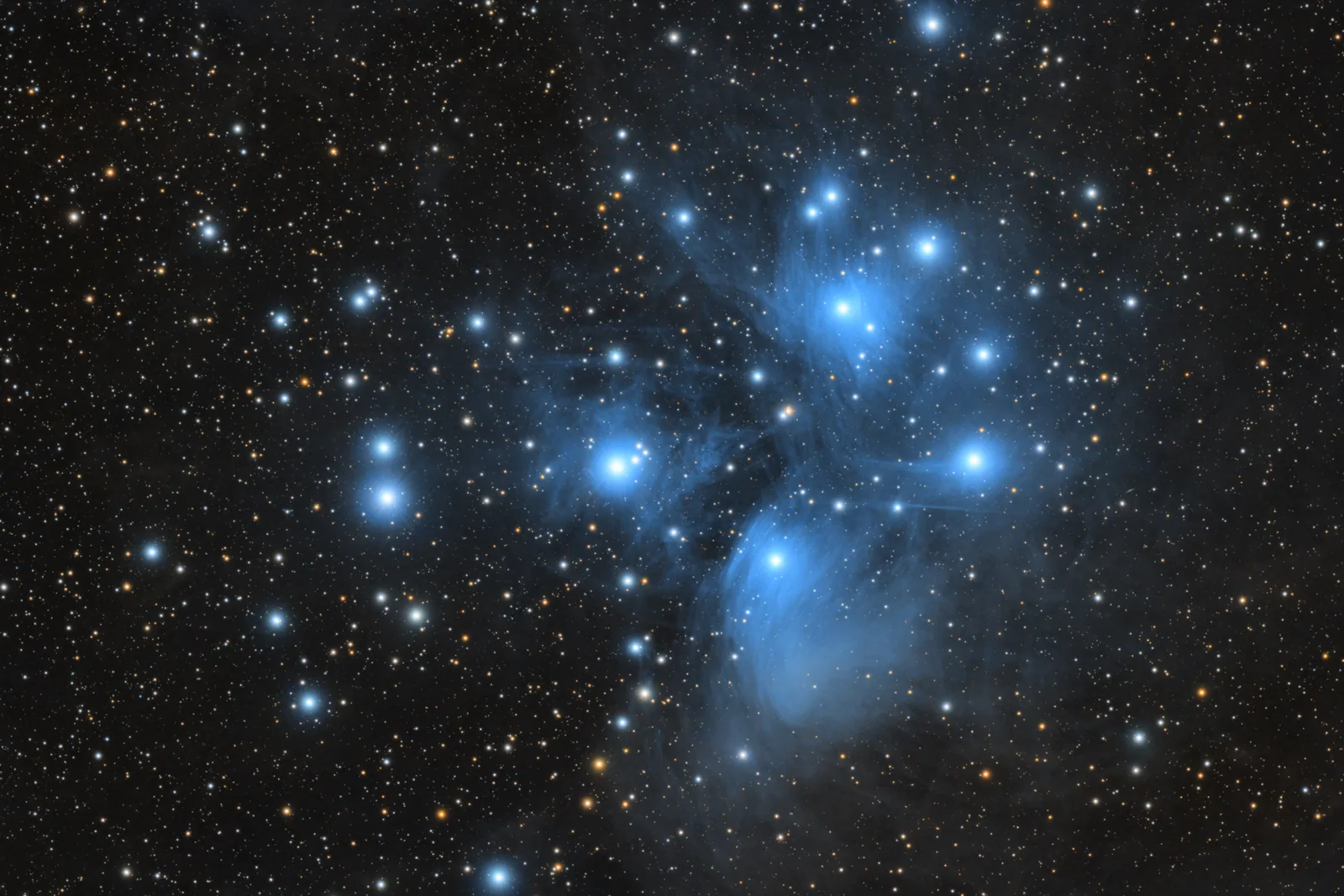 The Pleiades star cluster wrapped in faint blue reflection nebulosity.