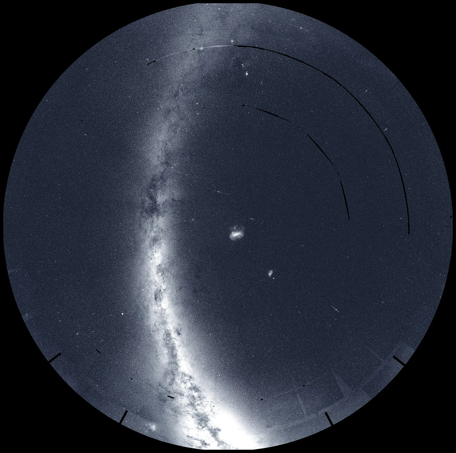 A round map of the southern sky with the Milky Way arcing across it and a small bright galaxy near the centre.