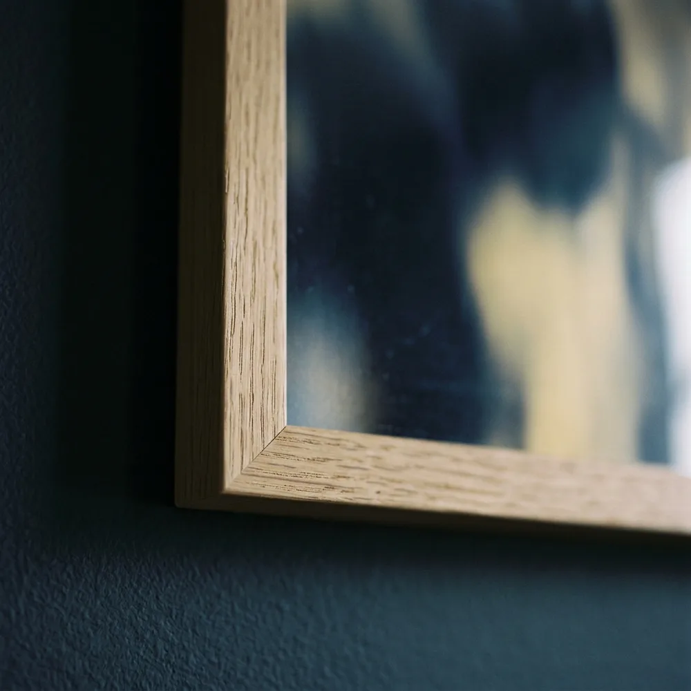 The mitre joint of a plain wood frame, the sheet reaching the timber on every side