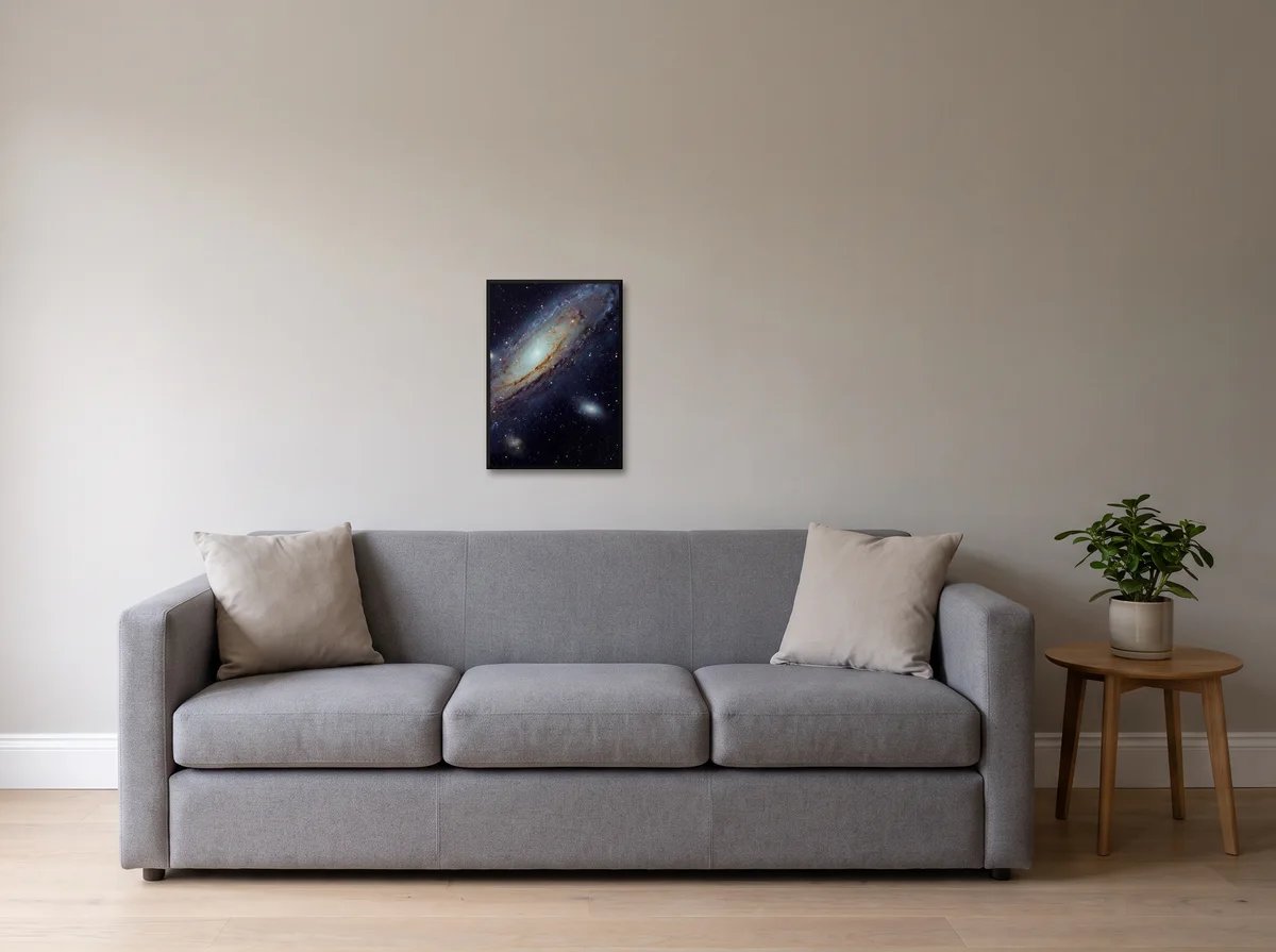 Andromeda as an A2 poster in a black frame on a light grey wall above a grey sofa