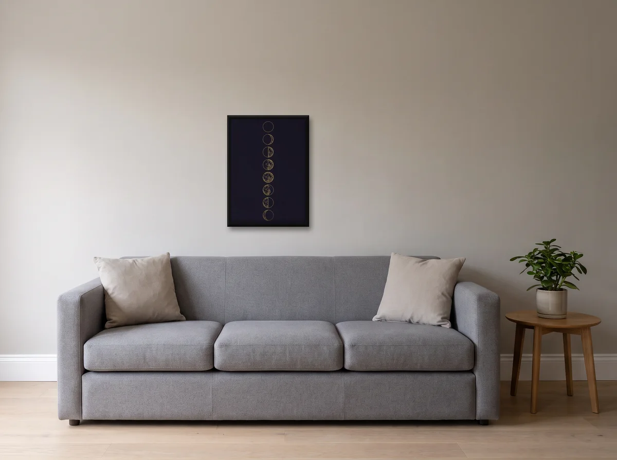 Lunar Phases as a 50x70 cm canvas in a black float frame on a light grey wall above a grey sofa