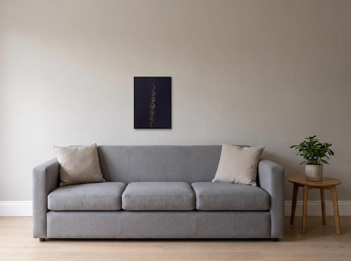Lunar Phases as an A2 print in a black frame on a light grey wall above a grey sofa.