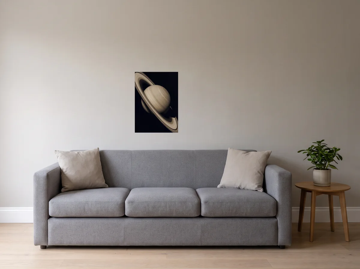 Saturn as a 50x70 cm poster on a light grey wall above a grey sofa