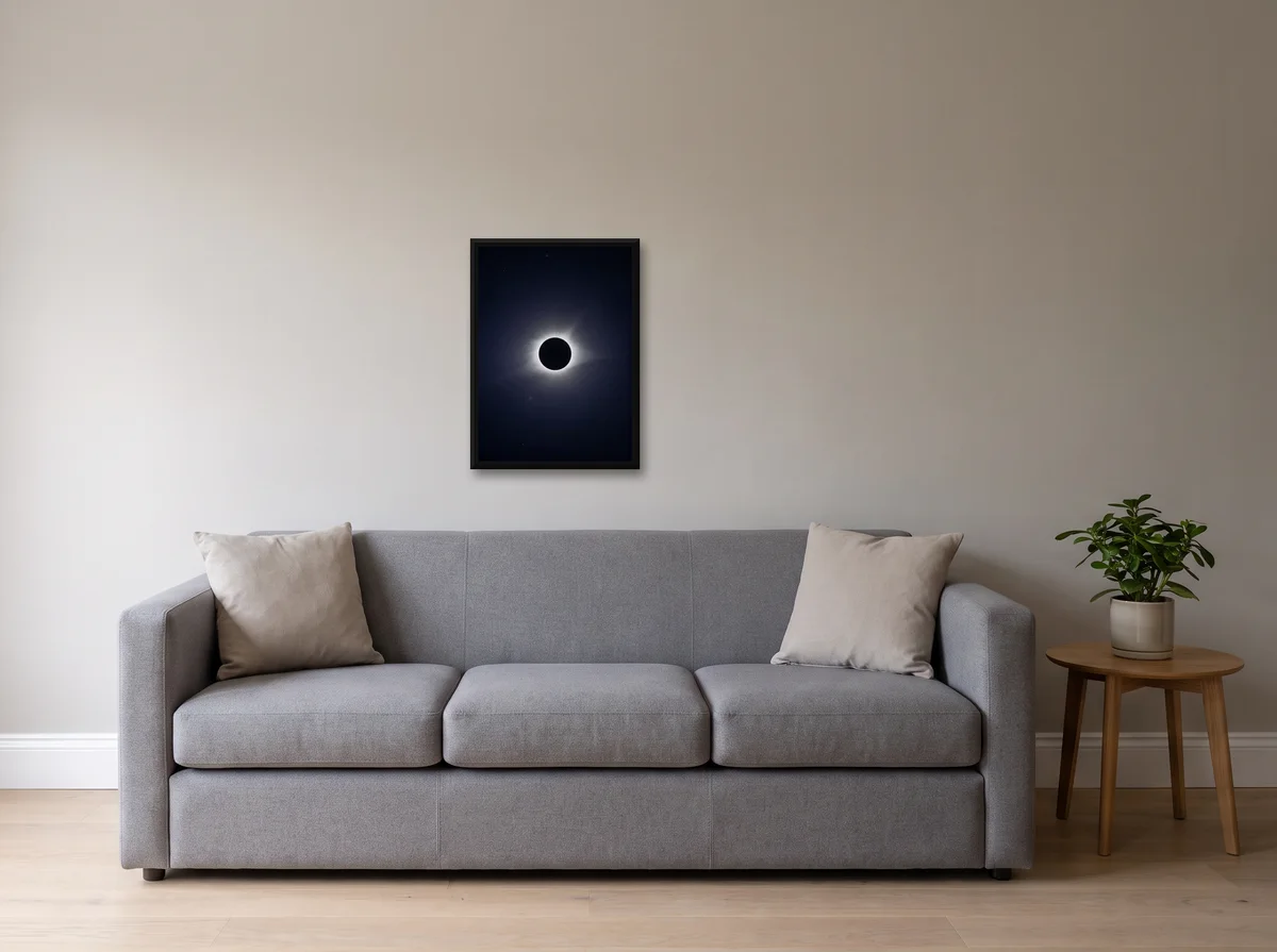 Totality as a 50 x 70 cm canvas in a black float frame on a light grey wall above a grey sofa.