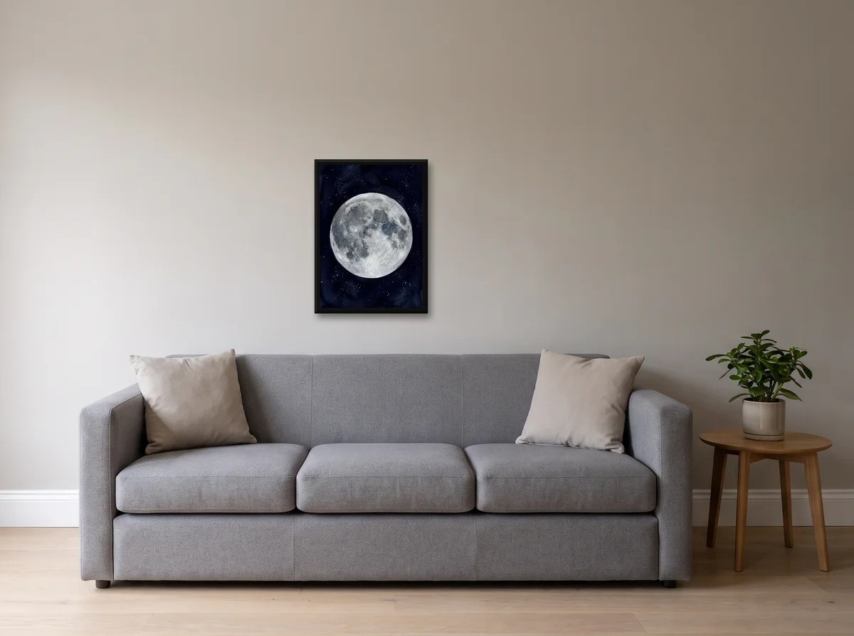 Watercolour Moon as a 50x70 cm canvas in a black float frame on a light grey wall above a grey sofa